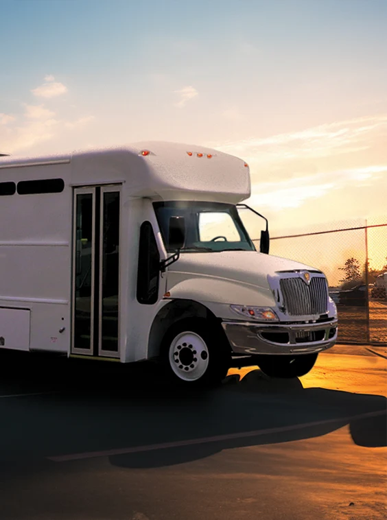 White shuttle bus parked next to a security fence at a prison near Pittsburgh